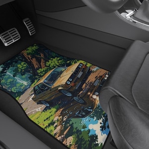 Op de afbeelding: Vloermatten voor auto's met een kleurrijk ontwerp in anime-stijl. De matten tonen een vintage auto die over een weg door een bos rijdt. Het kleurenpalet omvat groen, bruin en blauw, waardoor een levendige en gedetailleerde scène ontstaat.