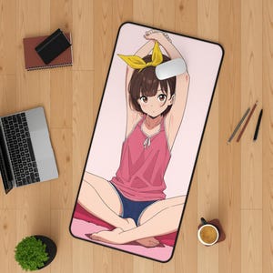 Puede incluir: Una alfombrilla de escritorio rectangular con una ilustración estilo anime de una persona con cabello castaño corto y un lazo amarillo, vistiendo una camiseta sin mangas rosa y pantalones cortos azules, sentada con los brazos levantados.