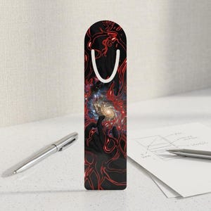 Puede incluir: Un marcapáginas rectangular vertical con un diseño abstracto oscuro de líneas rojas fluidas que parecen venas o raíces. En el centro, una vibrante galaxia espiral se representa sobre un fondo negro profundo con pequeñas estrellas.