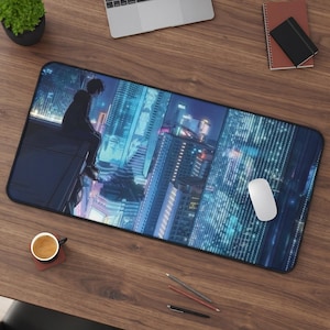 Puede incluir: Una alfombrilla de escritorio rectangular con una ilustración digital de una persona sentada en una azotea con vistas a una ciudad iluminada por luces de neón durante la noche. La obra muestra una paleta de colores azul y violeta vibrantes.