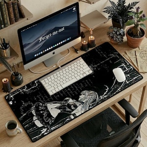 Peut inclure: Tapis de bureau noir avec une illustration de style manga d'une femme. Le tapis présente un motif semblable à du marbre et est associé à un clavier, une souris et un écran d'ordinateur blancs. L'écran affiche le texte "Forget-me-not".