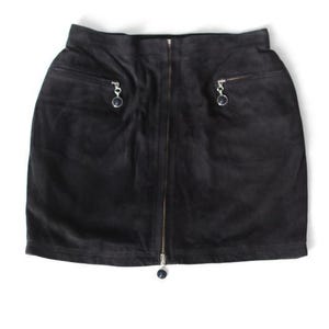 May include: A black suede mini skirt with a front zipper closure and two front pockets. Each pocket has a small silver zipper pull. The skirt is a solid black color and appears to be made of soft suede material.