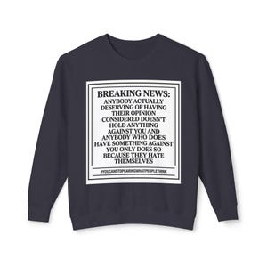 Puede incluir: Sudadera azul marino con un gráfico rectangular blanco. El gráfico presenta el texto "BREAKING NEWS: ANYBODY ACTUALLY DESERVING OF HAVING THEIR OPINION CONSIDERED DOESN'T HOLD ANYTHING AGAINST YOU..." y el hashtag "#YOUCANSTOPCARINGWHATPEOPLETHINK".