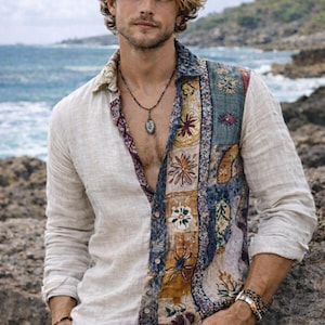 May include: A beige long-sleeved shirt with a patterned patchwork panel on the right side. The panel features floral and geometric designs in blue, yellow, and red. The model is wearing a necklace and bracelets.