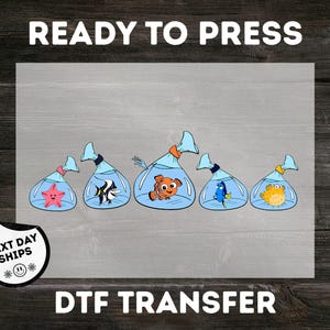 May include: DTF transfer featuring five cartoon fish in bags. The fish include a starfish, a black and white striped fish, an orange clownfish, a blue fish, and a yellow pufferfish. The words "READY TO PRESS" and "DTF TRANSFER" are printed on the image.