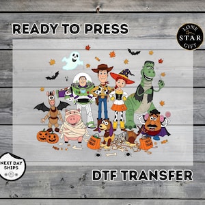 May include: A DTF transfer featuring a group of cartoon characters dressed in Halloween costumes, including a space ranger, a cowboy, a cowgirl, a dinosaur, a pig, a dog, and a potato figure, surrounded by pumpkins, bats, and autumn leaves.