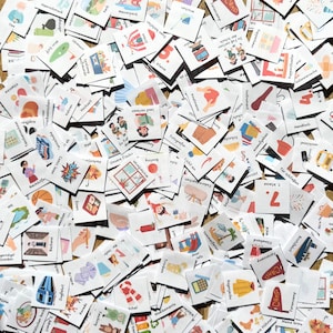 May include: A large collection of square white cards featuring colorful illustrations and German text labels. Each card depicts a different daily activity, object, or concept, such as school subjects, weather, food, and leisure items, scattered in a dense, overlapping arrangement.