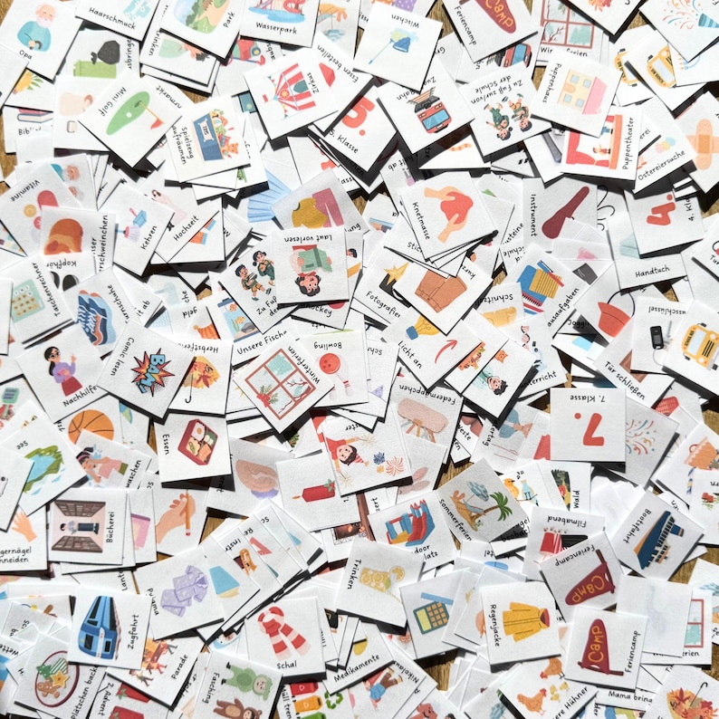 May include: A large collection of square white cards featuring colorful illustrations and German text labels. Each card depicts a different daily activity, object, or concept, such as school subjects, weather, food, and leisure items, scattered in a dense, overlapping arrangement.