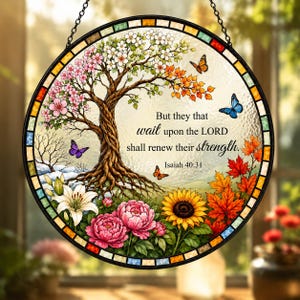 May include: A circular stained glass suncatcher featuring a tree with seasonal foliage, butterflies, and flowers. The text reads: But they that wait upon the LORD shall renew their strength. Isaiah 40:31. The border is composed of small, multicoloured glass tiles.