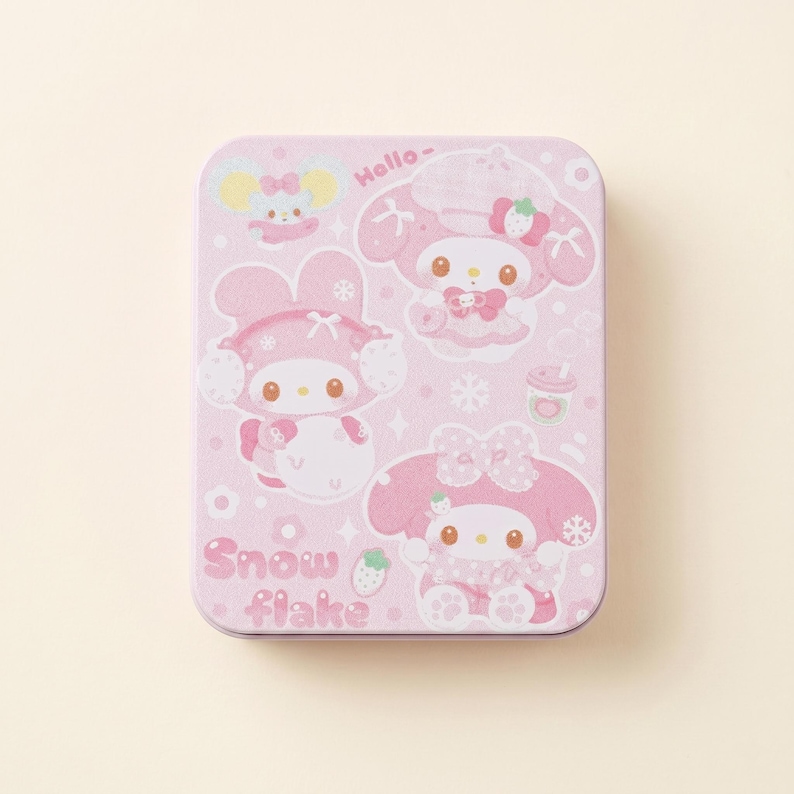 May include: A rectangular pink tin featuring cartoon characters in winter attire. The tin has a light pink background with illustrations of characters wearing hats and bows. The text "Hello-" and "Snow flake" are also visible.