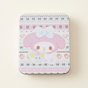 May include: A rectangular tin featuring a pink cartoon character with a large bow, holding a small mouse. The tin has a light pink, white, and gray pattern with bows and other characters. The tin is approximately 4 inches long and 3 inches wide.