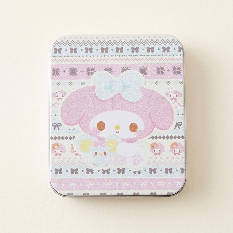 May include: A rectangular tin featuring a pink cartoon character with a large bow, holding a small mouse. The tin has a light pink, white, and gray pattern with bows and other characters. The tin is approximately 4 inches long and 3 inches wide.