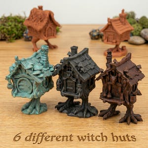 Peut inclure: Six petites cabanes de sorcières de différentes couleurs, dont marron, turquoise et noir. Chaque cabane a un design unique, avec des détails comme des cheminées, des portes et des bases en forme d'arbre. Le texte "6 different witch huts" est en bas.