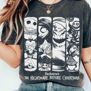 May include: Dark grey t-shirt with a graphic from Tim Burton's "The Nightmare Before Christmas." The design features Jack Skellington, Sally, Oogie Boogie, and other characters. The text "Tim Burton's The Nightmare Before Christmas" is printed at the bottom.