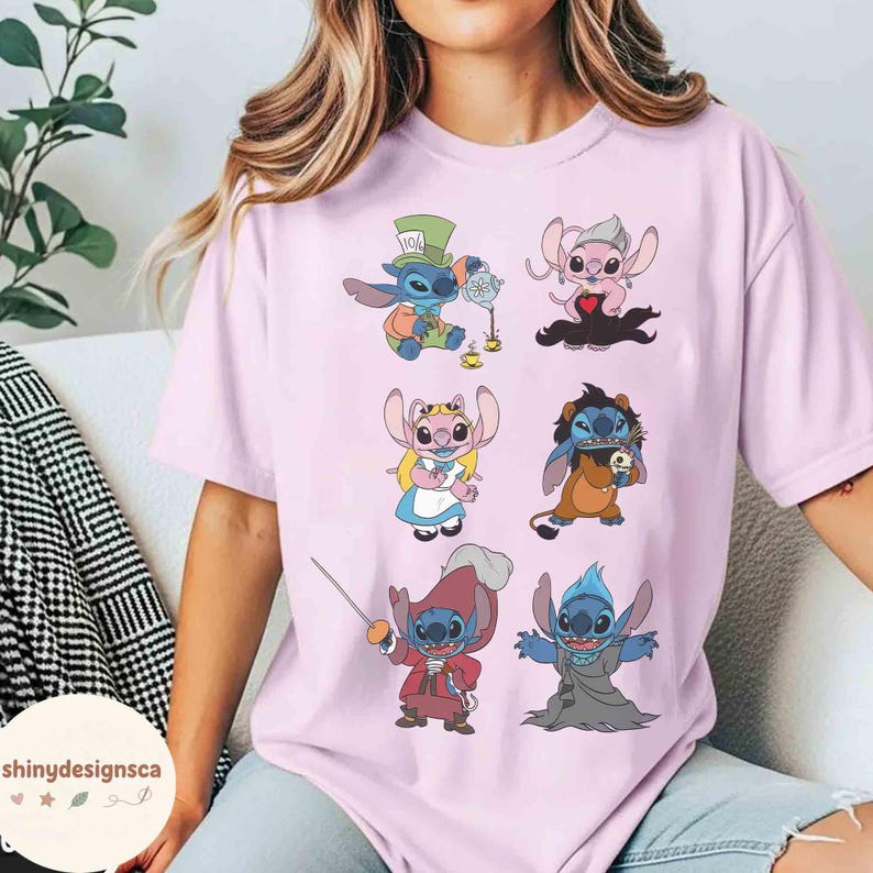 K&ouml;nnte beinhalten: Hellrosa T-Shirt mit Illustrationen von Cartoon-Charakteren. Die Illustrationen zeigen einen blauen Alien-Charakter in verschiedenen Kost&uuml;men, darunter ein Hutmacher, eine K&ouml;nigin und ein B&ouml;sewicht. Der Text "shinydesignsca" ist auf dem Shirt aufgedruckt.