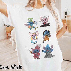K&ouml;nnte beinhalten: Wei&szlig;es T-Shirt mit farbenfrohen Cartoon-Illustrationen von Stitch-Charakteren in verschiedenen Kost&uuml;men. Das Shirt hat unten den Text "Color: White". Die Illustrationen zeigen Stitch als Hutmacher, Angel und andere Charaktere.