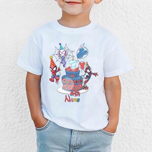 May include: White t-shirt featuring a colorful graphic of Spider-Man characters celebrating a birthday. The design includes a cake, balloons, and the word "Name". The number 7 is on the cake.