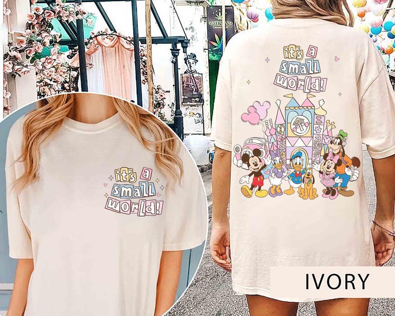Pu&ograve; includere: T-shirt color avorio con la scritta "it's a small world!" sul davanti e sul retro. Il retro presenta una grafica colorata di un castello e dei personaggi Disney, tra cui Topolino, Paperino e Pippo.