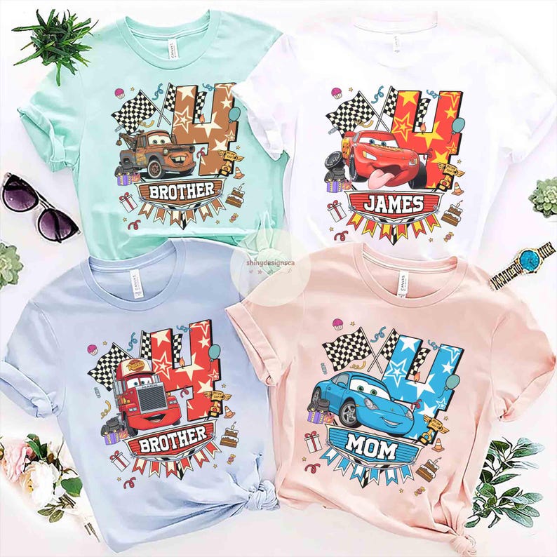 May include: Four short-sleeved t-shirts in pastel colors: mint green, white, light blue, and pink. Each shirt features a cartoon car design with the number 4 and the words "Brother", "James", and "Mom". Checkered flags and birthday cake graphics are also included.
