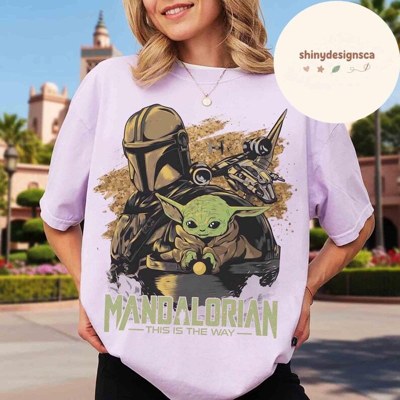 Puede incluir: Una camiseta lila con un gr&aacute;fico de The Mandalorian y Grogu de Star Wars. El dise&ntilde;o incluye el texto "MANDALORIAN - THIS IS THE WAY" en verde y blanco.