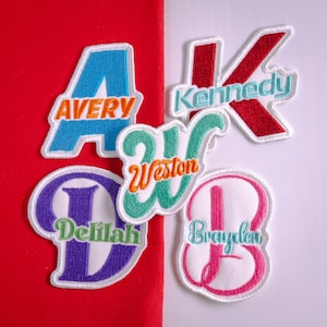May include: Five embroidered fabric patches featuring large letters in blue, red, green, purple, and pink. Each patch displays a name stitched in a contrasting color: Avery, Kennedy, Weston, Delilah, and Brayden. The patches have white borders.