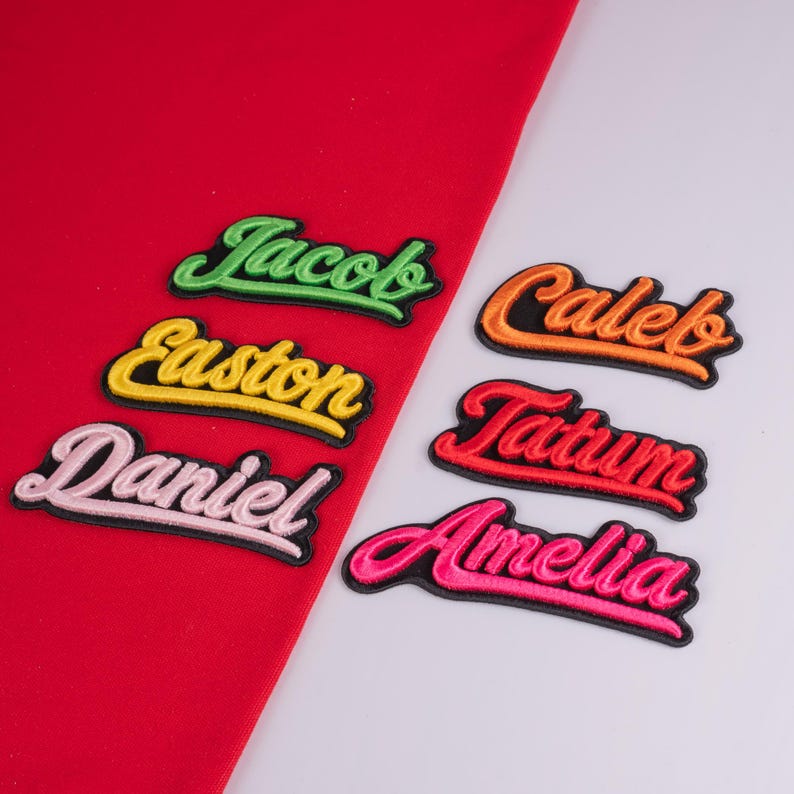 May include: Six embroidered name patches with black borders and cursive lettering. The names Jacob, Easton, and Daniel are in lime green, yellow, and light pink on a red fabric background. Caleb, Tatum, and Amelia are in orange, red, and hot pink.