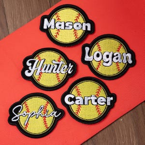 May include: Embroidered softball patches with names: Mason, Hunter, Logan, Sophia, and Carter. Each patch features a yellow softball design with red stitching, a black border, and white lettering. Patches are on a red surface.