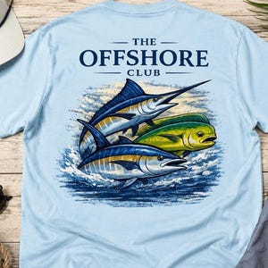 May include: Light blue t-shirt featuring a graphic of three fish: a marlin, a mahi-mahi, and a tuna, with the text "THE OFFSHORE CLUB" above. The fish are depicted in shades of blue, yellow, and green, set against a backdrop of ocean waves.
