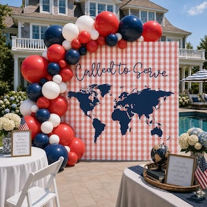 May include: A festive outdoor scene with a red and white checkered backdrop featuring a world map and the words "Called to Serve." A balloon arch in red, white, and blue frames the backdrop. Tables are set with patriotic decor, including flags and framed quotes.