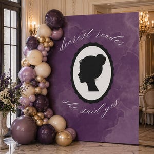 May include: A purple backdrop with the text "dearest reader" and "she said yes" in elegant script. A black silhouette of a woman's profile is in an oval frame. A balloon arch in shades of purple, gold, and cream decorates the scene.