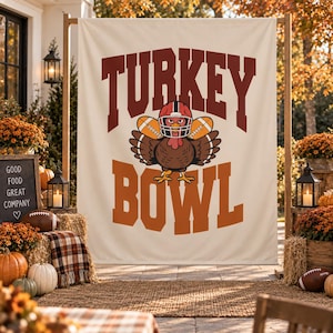 Könnte beinhalten: Ein cremefarbenes Stoffbanner mit dem Text TURKEY BOWL in großen, fetten, dunkelroten und orangefarbenen Buchstaben. Zwischen den Wörtern befindet sich ein Cartoon-Truthahn, der einen Footballhelm trägt und zwei Footballs unter den Flügeln hält.