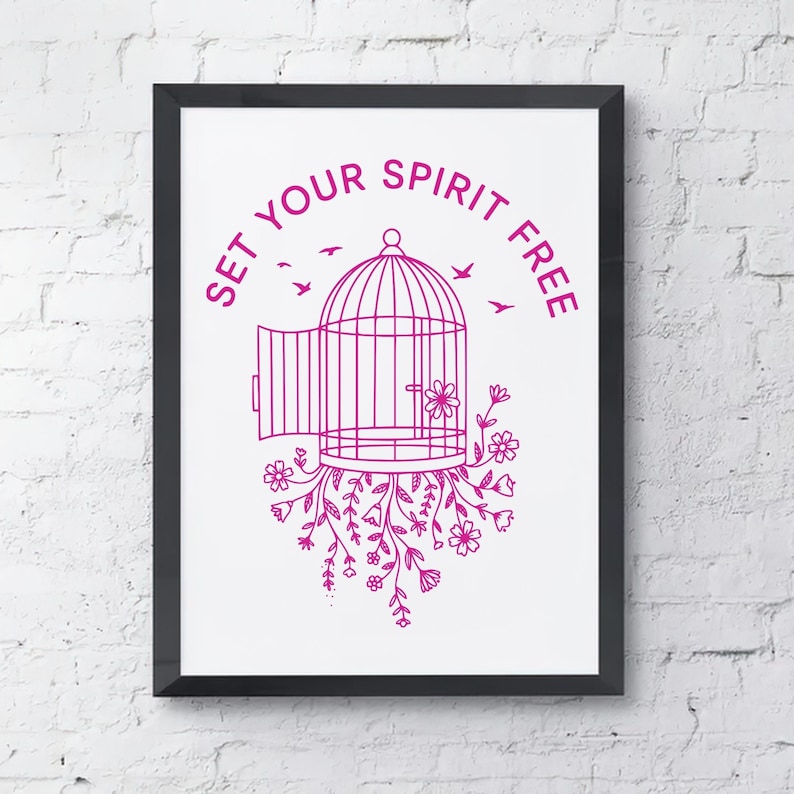 May include: A framed print with a black border features a magenta illustration of a birdcage with an open door, flowers, and birds. The text "SET YOUR SPIRIT FREE" is arched above the cage. The artwork is set against a white background.
