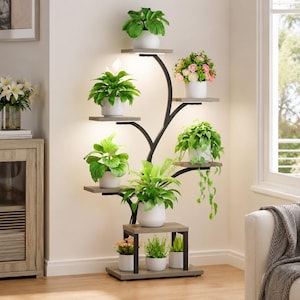 May include: A tall, tree-shaped plant stand with a black metal frame and multiple gray wooden shelves. The stand features integrated LED grow lights above several shelves, holding various potted green plants and flowers in white ceramic pots.