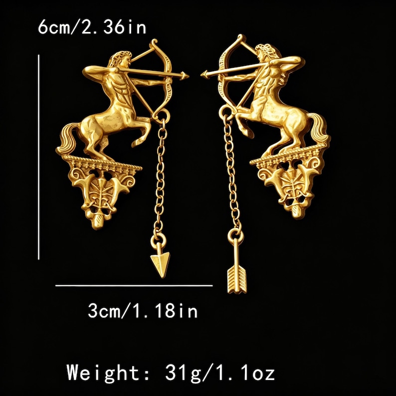 May include: A pair of gold-coloured earrings featuring a centaur with a bow and arrow design. Each earring is 6 cm long and 3 cm wide, with a weight of 31g. The earrings have a chain with an arrow pendant.