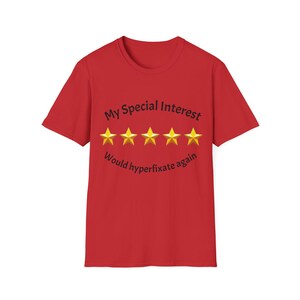 May include: Red t-shirt featuring the text "My Special Interest" above five gold stars and the phrase "Would hyperfixate again" below. The shirt has a crew neck and short sleeves.