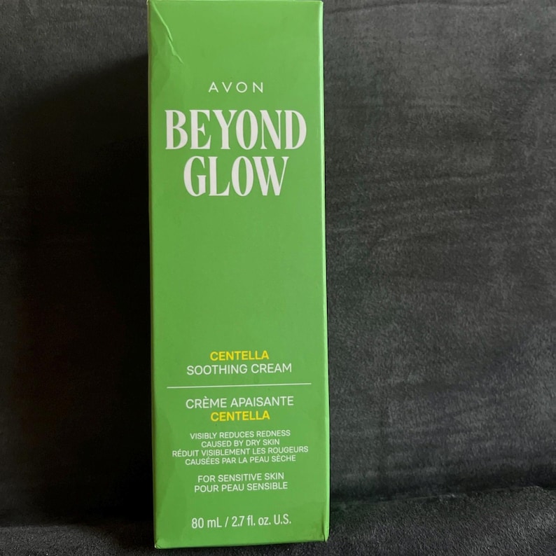 Pu&ograve; includere: Una scatola verde di Avon Beyond Glow Centella Soothing Cream. La scatola presenta un testo bianco che recita "Beyond Glow" e "Centella Soothing Cream". La scatola indica anche che il prodotto &egrave; per pelli sensibili e contiene 80 ml.
