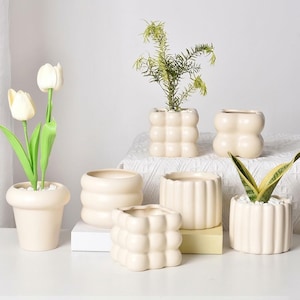 Può includere: Un set di tre tazze in ceramica con finitura opaca e macchiettata. Le tazze sono nei toni del crema, marrone chiaro e marrone scuro. Ogni tazza ha un design semplice e minimalista e un manico arrotondato.