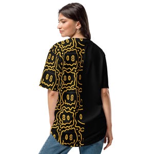 May include: Black and yellow short-sleeved shirt with a distinctive design. The left side displays a repeating pattern of yellow smiley faces on a black backdrop. The right side is plain black.