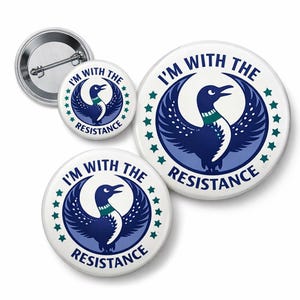 May include: A collection of white buttons with a blue and green loon design and the text "I'M WITH THE RESISTANCE." The buttons vary in size and feature a pin back.