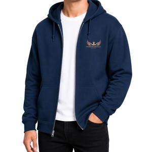 May include: A navy blue zip-up hoodie with a hood and front pockets. The hoodie features a small logo on the upper left chest with the text "NOREHEARSALS EST. 2020". The model is wearing a white t-shirt underneath.