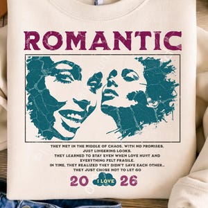 Puede incluir: Sudadera color crema con la palabra "ROMANTIC" en fuente rosa oscuro. Debajo, un gráfico turquesa de dos caras. La sudadera tiene el texto "THEY MET IN THE MIDDLE OF CHAOS...THEY JUST CHOSE NOT TO LET GO".