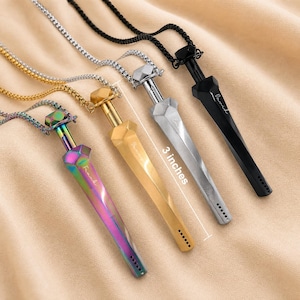 May include: Four sword-shaped pendants on matching box chains in iridescent, gold, silver, and black finishes. Each pendant measures 3 inches in length and features a faceted hilt, a tapered blade, and a small engraved name on the side.