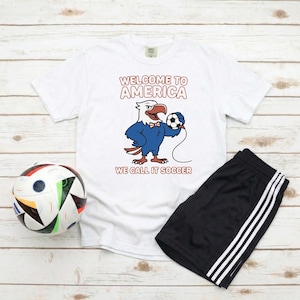 アメリカへようこそ！サッカーTシャツ｜面白いイーグルUSAサッカーファンTシャツ。ワールドカップ2026観戦パーティー、ユニセックスの試合当日ギフトに。