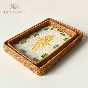 May include: Two rectangular woven rattan trays nested together. The base of each tray features a mosaic inlay with a white background, a central yellow floral pattern, and green square accents along the border. The brand name LOTUSCRAFT is visible.