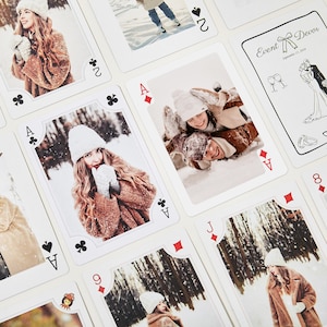 May include: A collection of playing cards, each displaying a photograph. The images show people in winter attire, with one card featuring a couple in the snow. One card has the text "Event Devor, September 21, 2024" with wedding illustrations. The cards are white with black and red suit symbols.