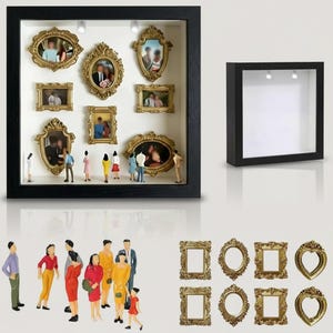 Może przedstawiać: Czarny box z białym wnętrzem, prezentujący miniaturowe zdjęcia w złotych ramkach i małe figurki. Dodatkowe złote ramki i figurki pokazano osobno. Pokazano również drugi czarny box.