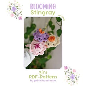 Könnte beinhalten: Drei kleine gehäkelte Rochenfiguren in Helllila, Hellrosa und Creme. Der lila Rochen hat eine orangefarbene Mitte, der rosa Rochen ein dunkelrosa Sternmuster und der cremefarbene eine orangefarbene Mitte. Text: BLOOMING Stingray, no sew!, 3in1 PDF-Pattern by @rikki.handmade.