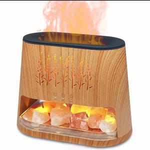 May include: A wooden-look essential oil diffuser with a flame effect. The diffuser has a rectangular base with a display of pink and orange salt rocks. The front of the diffuser has a cut-out floral design. The top has a dark rim.