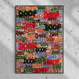 May include: A framed artwork with the word "DOOF" in graffiti style, repeated across the canvas in multiple colours. The colours include red, green, blue, and orange, set against a white backdrop. The artwork is displayed on a concrete wall.