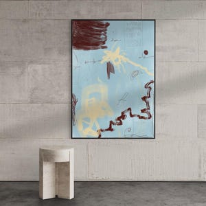 May include: A rectangular wall art piece featuring an abstract composition on a light blue background. The artwork includes dark brown brushstrokes, a yellow star-like shape, a jagged brown line, and faint white line drawings in a black frame.